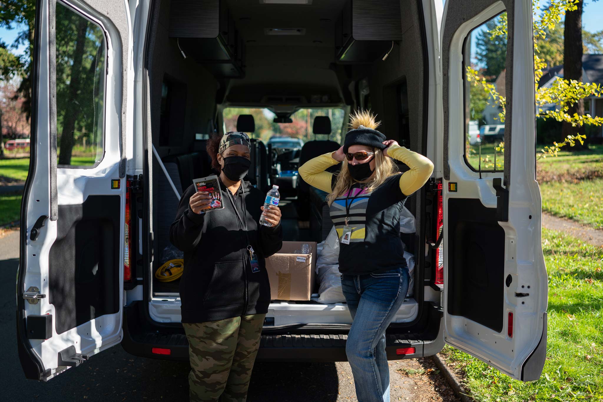 two people unloading the back of the bridges to change community outreach sprinter van