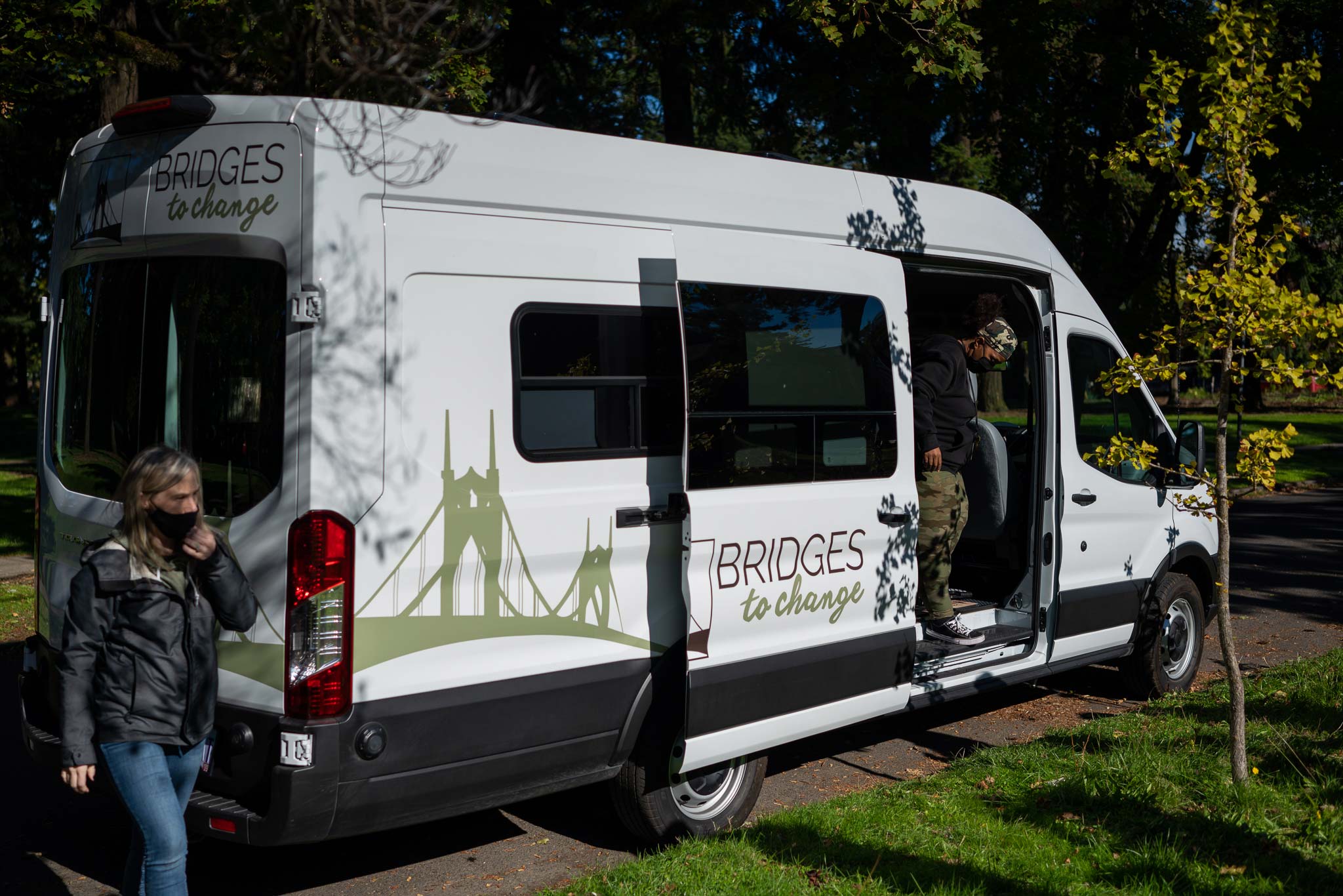 two people exiting the bridges to change community outreach van